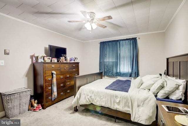 carpeted bedroom with crown molding and a ceiling fan