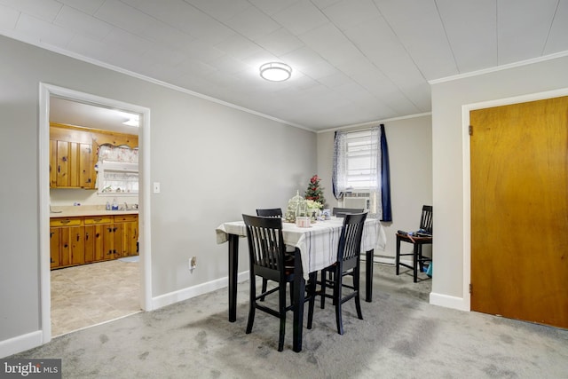 dining room featuring ornamental molding, baseboards, and light carpet