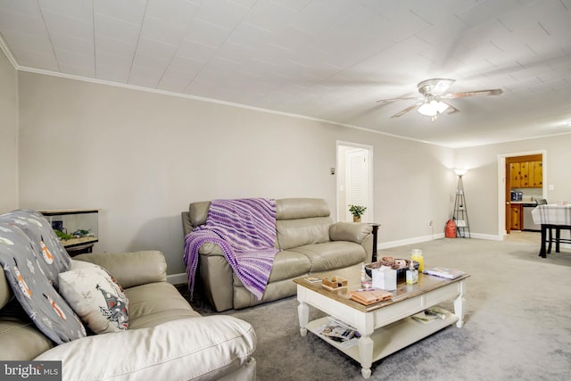 living area with crown molding, light colored carpet, baseboards, and ceiling fan