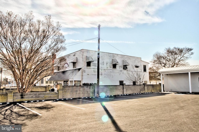 view of side of home with fence and uncovered parking