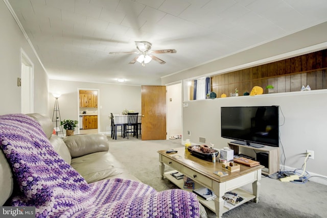 living area featuring carpet, baseboards, and ceiling fan