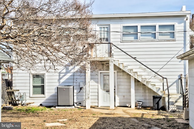 back of house featuring central air condition unit and stairs