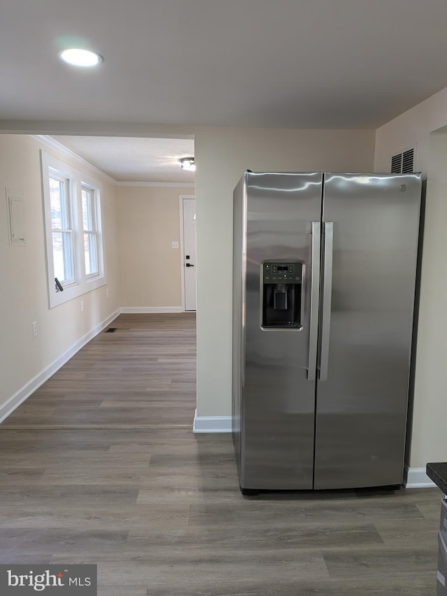 kitchen with visible vents, wood finished floors, baseboards, and stainless steel fridge with ice dispenser