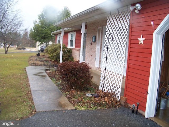 view of side of home with a yard and brick siding