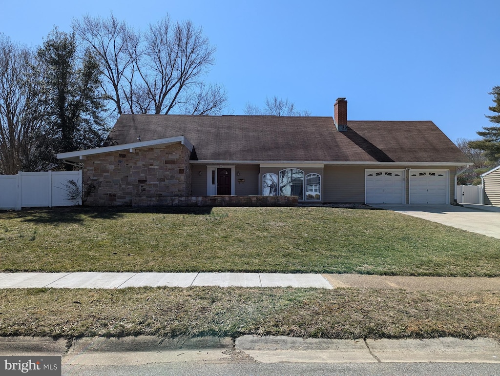 view of front facade featuring a garage, a front yard, fence, and concrete driveway