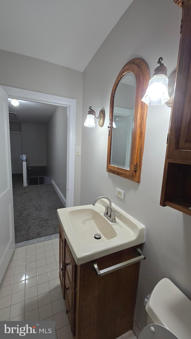 half bath with tile patterned flooring, toilet, and vanity