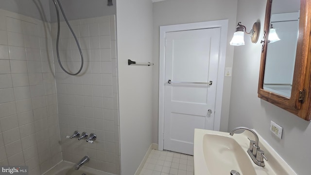 bathroom featuring a sink, shower / bathing tub combination, baseboards, and tile patterned flooring