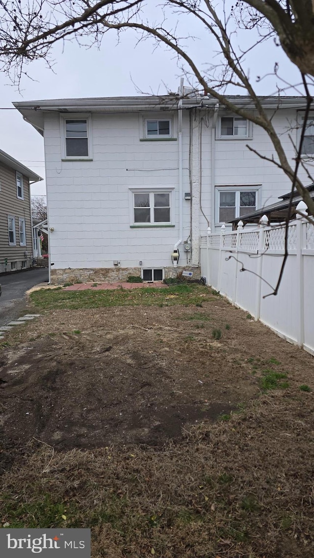 rear view of house featuring fence