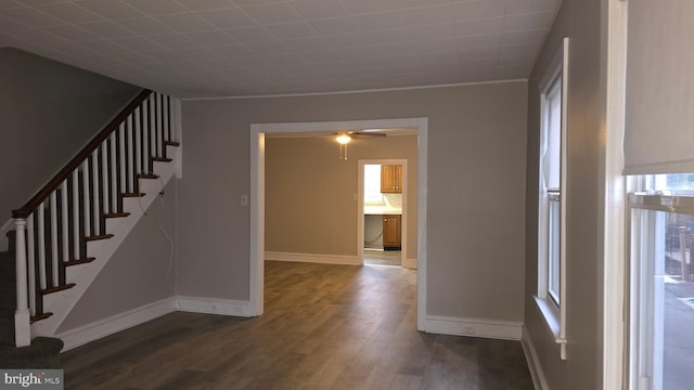 interior space featuring stairway, baseboards, dark wood-type flooring, and ceiling fan