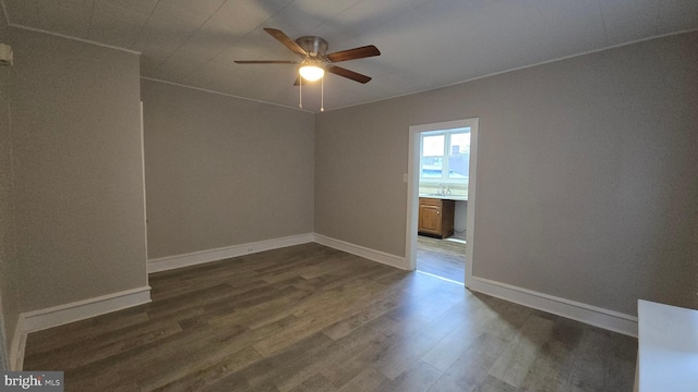 unfurnished room featuring baseboards, ceiling fan, and dark wood-style flooring