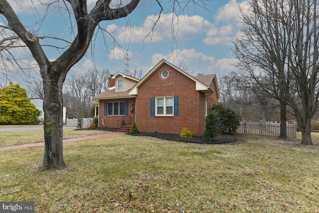 view of front of property featuring brick siding, a front lawn, and fence