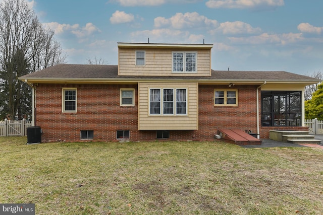 back of property featuring brick siding, a lawn, and fence