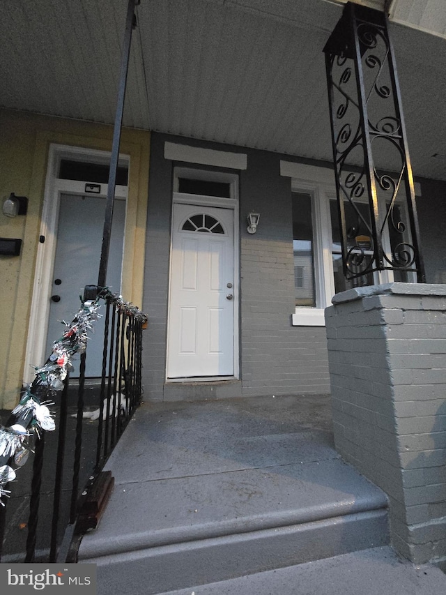 doorway to property with brick siding