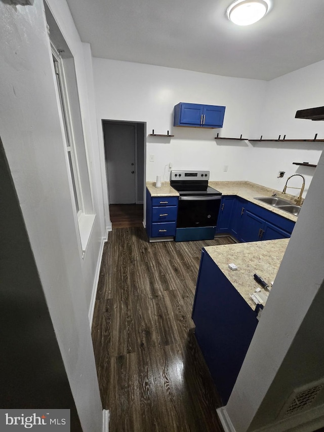 kitchen with blue cabinets, electric range, dark wood-type flooring, a sink, and light countertops