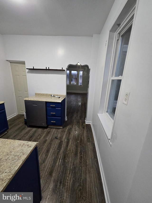 kitchen featuring blue cabinets, baseboards, dark wood-type flooring, and light countertops