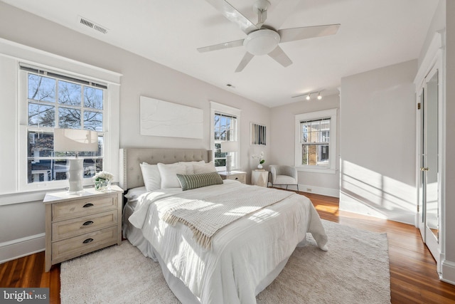 bedroom featuring light wood finished floors, visible vents, ceiling fan, and baseboards