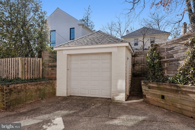 detached garage with driveway and fence