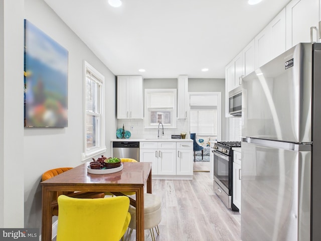 kitchen with white cabinetry, tasteful backsplash, appliances with stainless steel finishes, and a sink