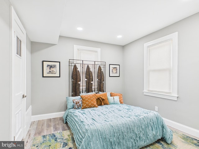 bedroom with recessed lighting, baseboards, and wood finished floors