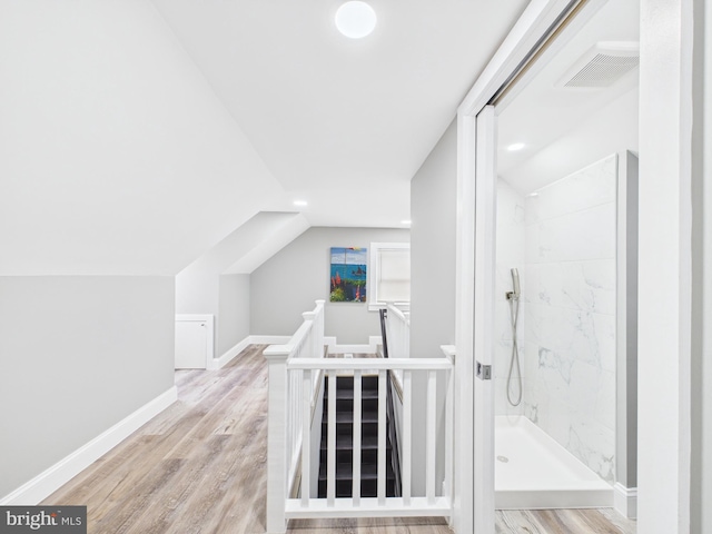 additional living space featuring visible vents, baseboards, lofted ceiling, and wood finished floors