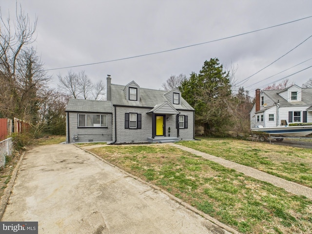 view of front of house featuring fence, a chimney, a front lawn, concrete driveway, and brick siding