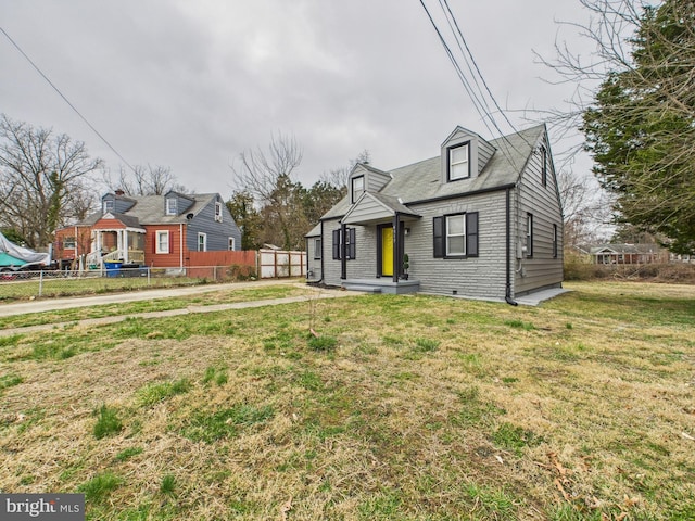 view of front of house featuring brick siding, a front lawn, and fence