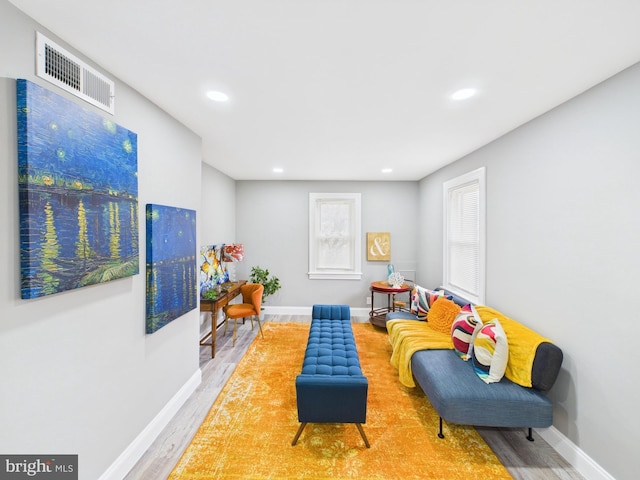 living room featuring visible vents, baseboards, and wood finished floors