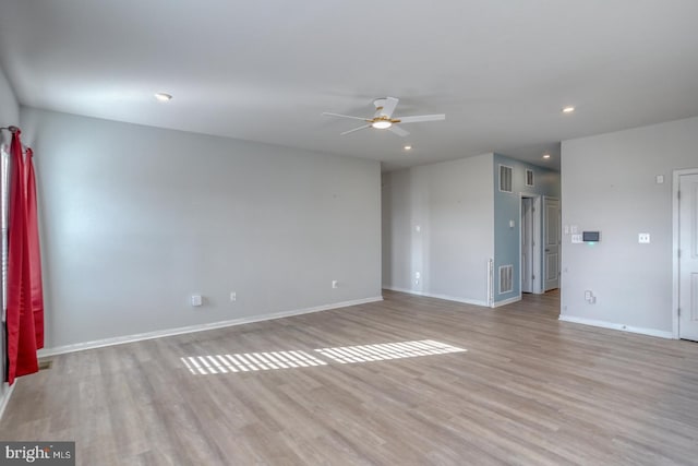 spare room featuring visible vents, baseboards, light wood-style floors, and ceiling fan