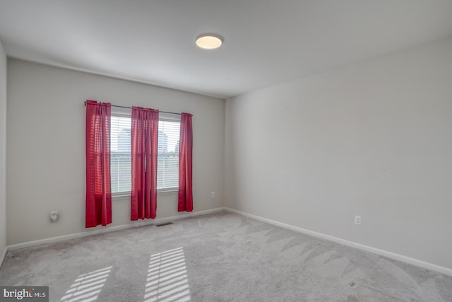 empty room with visible vents, baseboards, and carpet floors