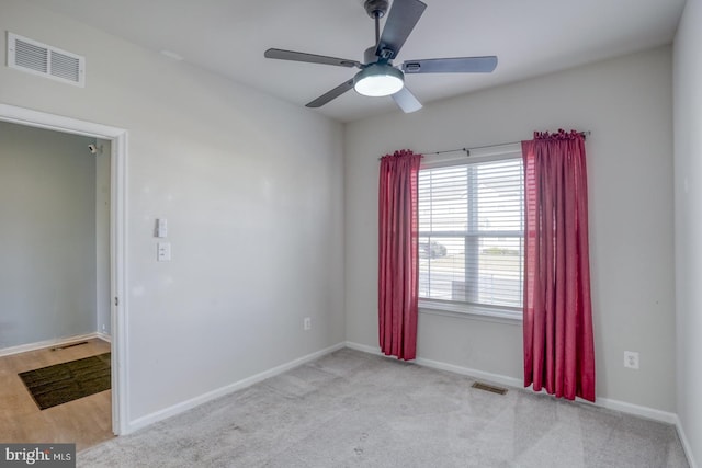 spare room with baseboards, visible vents, and ceiling fan