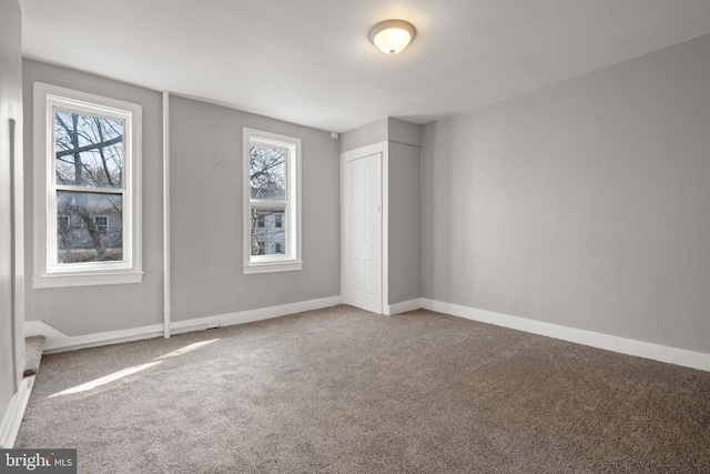 unfurnished bedroom with a closet, carpet flooring, and baseboards