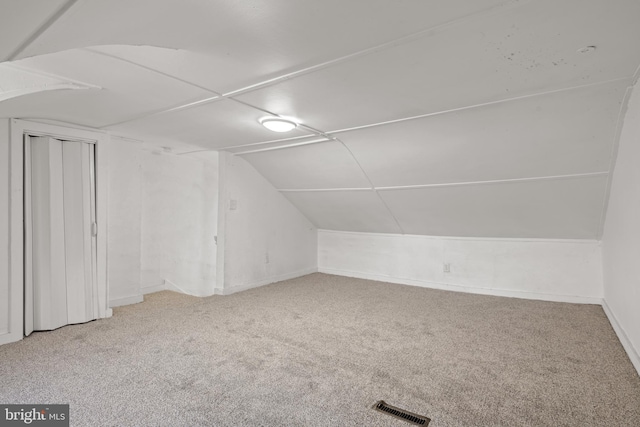 bonus room with vaulted ceiling, carpet flooring, and visible vents