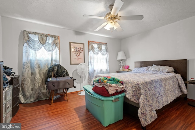 bedroom with baseboards, a textured ceiling, ceiling fan, and wood finished floors