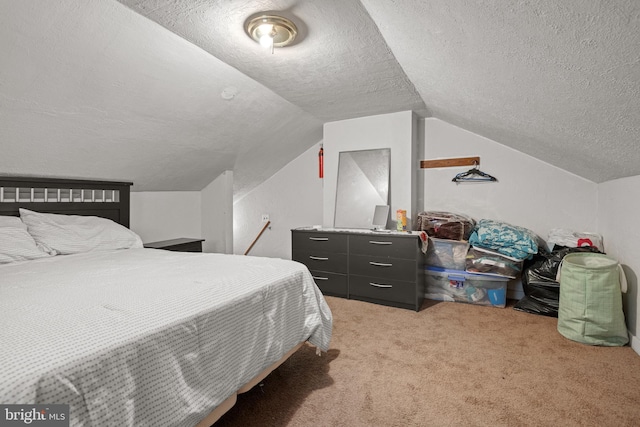 bedroom with a textured ceiling, carpet, and vaulted ceiling