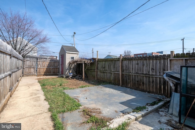 view of yard with an outbuilding, a fenced backyard, a storage shed, and a patio area