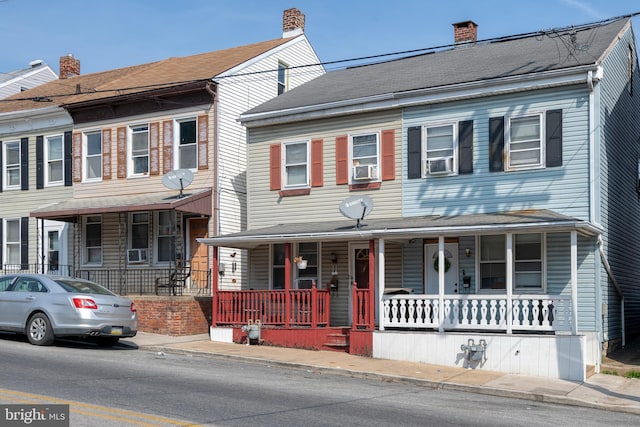 view of front of home featuring covered porch and a chimney