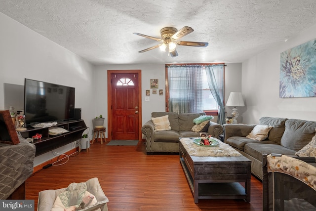 living room featuring a textured ceiling, wood finished floors, and a ceiling fan