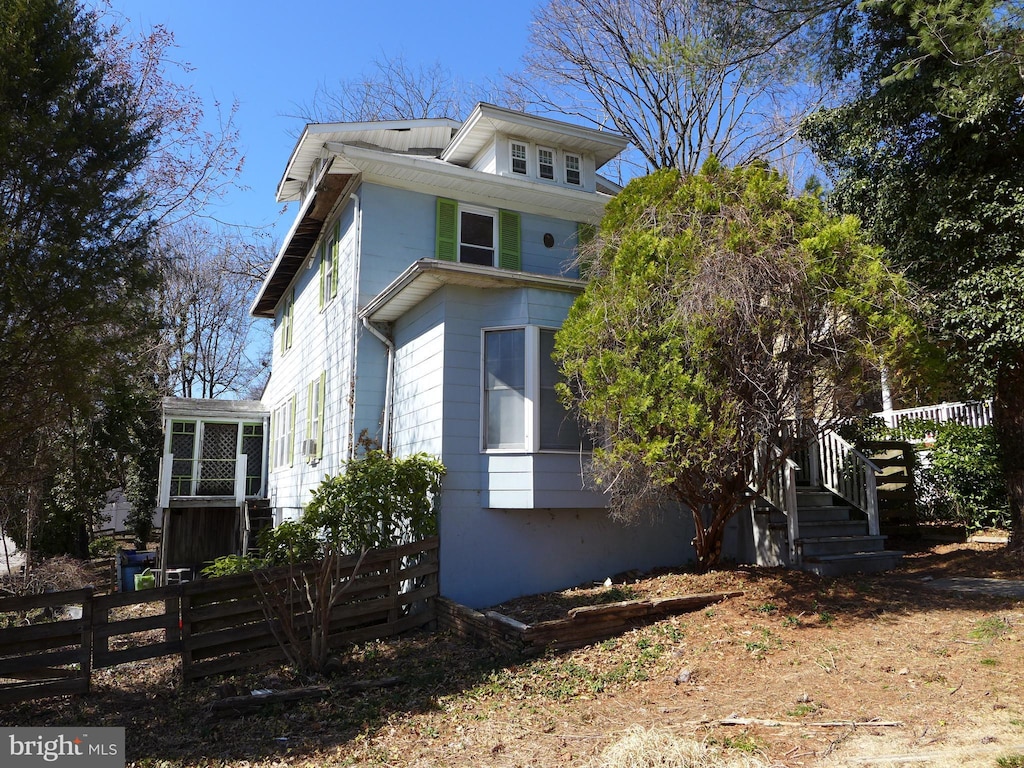 view of side of home featuring fence