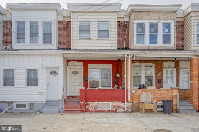 multi unit property with brick siding and a porch