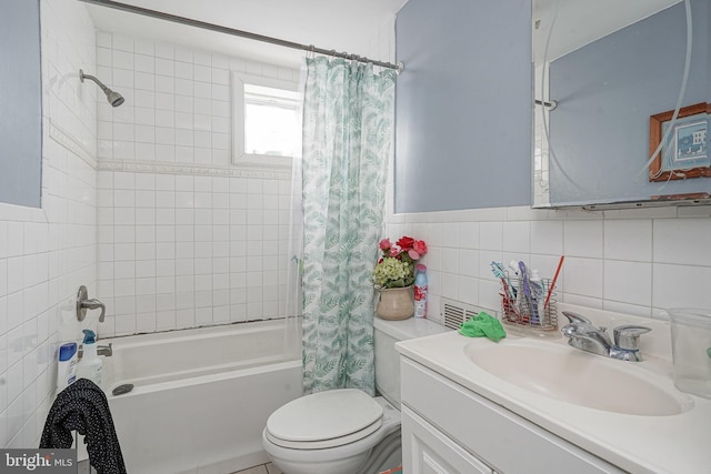 bathroom featuring vanity, shower / tub combo, wainscoting, tile walls, and toilet