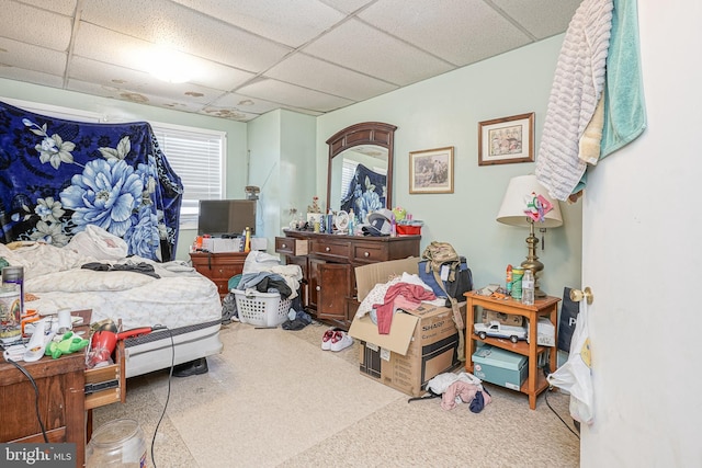 bedroom with a paneled ceiling and carpet floors