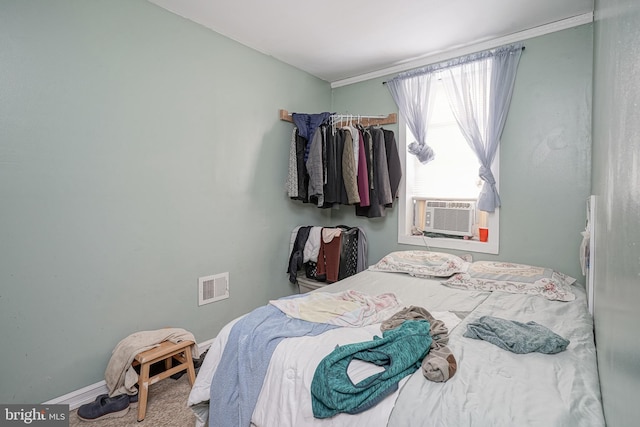 bedroom with visible vents, baseboards, and cooling unit