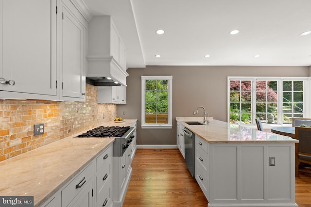 3517 Woodbine St, Chevy Chase, MD 20815 - kitchen with baseboards, light wood-type flooring, a sink, appliances with stainless steel finishes, and backsplash