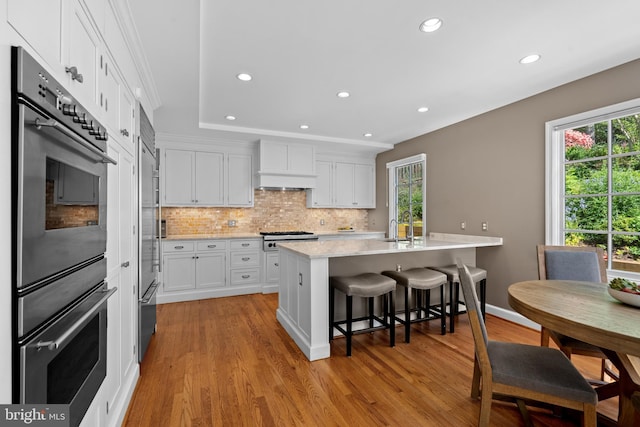 3517 Woodbine St, Chevy Chase, MD 20815 - kitchen featuring light wood-style floors, recessed lighting, white cabinets, tasteful backsplash, and appliances with stainless steel finishes