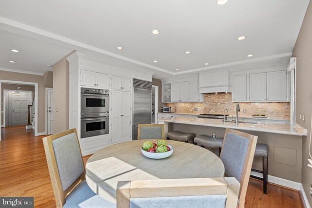 3517 Woodbine St, Chevy Chase, MD 20815 - dining space featuring light wood-style floors, baseboards, crown molding, and recessed lighting