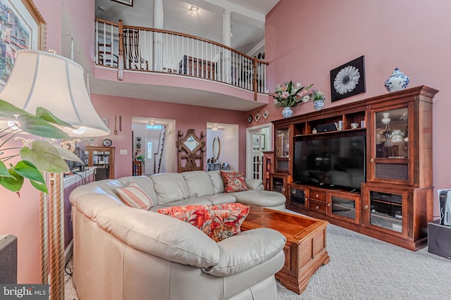 living area featuring carpet floors and a towering ceiling