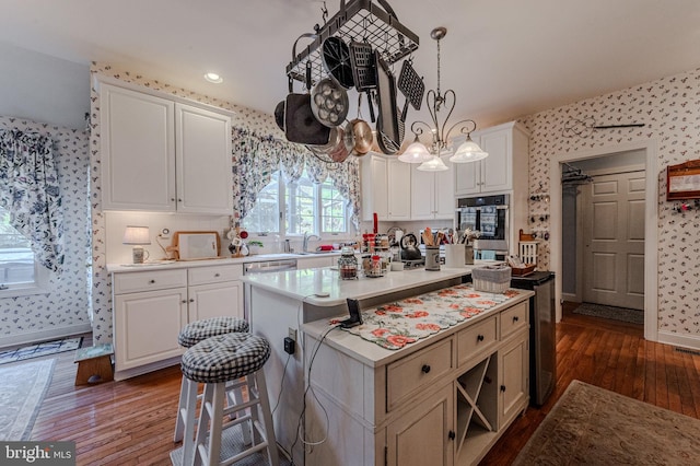 kitchen featuring white cabinetry, light countertops, and wallpapered walls