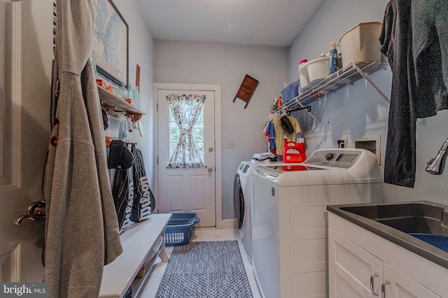 washroom with tile patterned floors, a sink, cabinet space, and separate washer and dryer