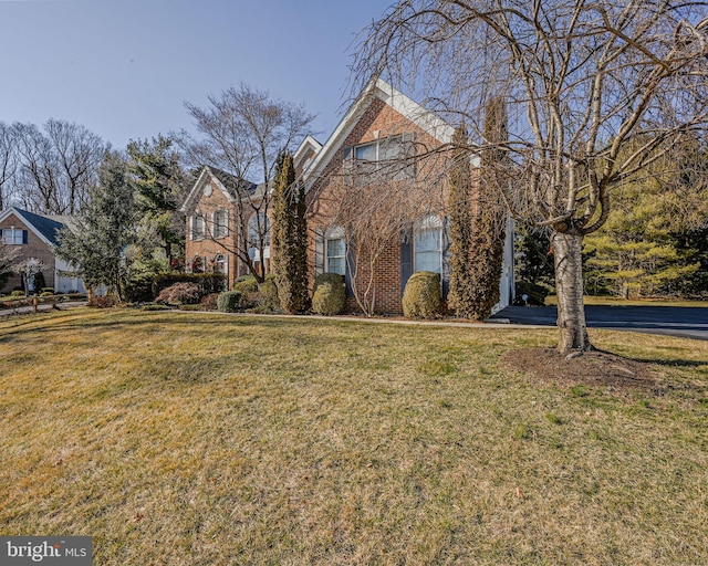 view of front of house featuring a front lawn and brick siding