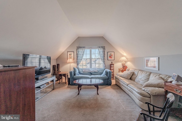 carpeted living area with vaulted ceiling